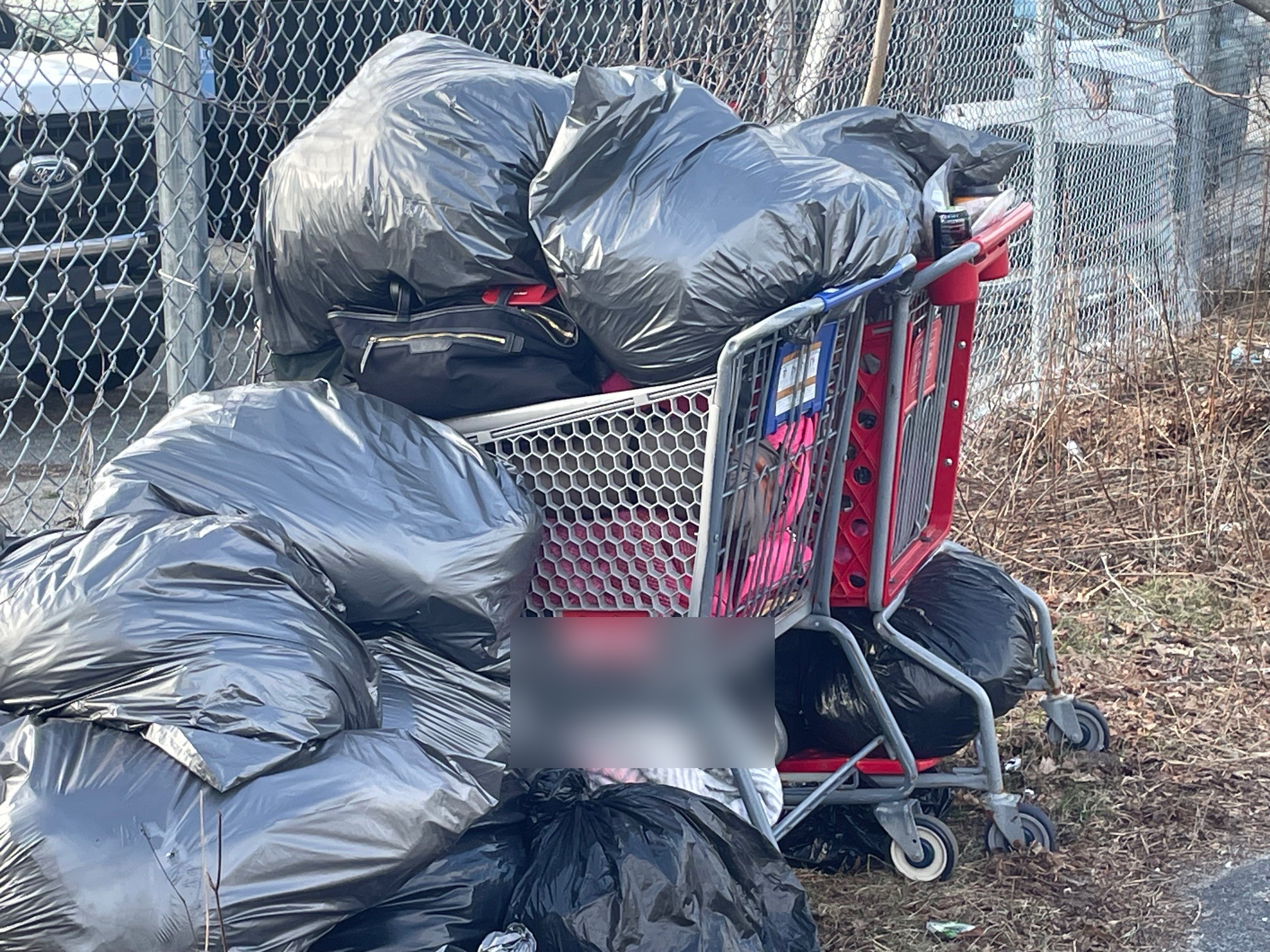 Shopping cart overflowing with bags outside 77 Winter Street shelter